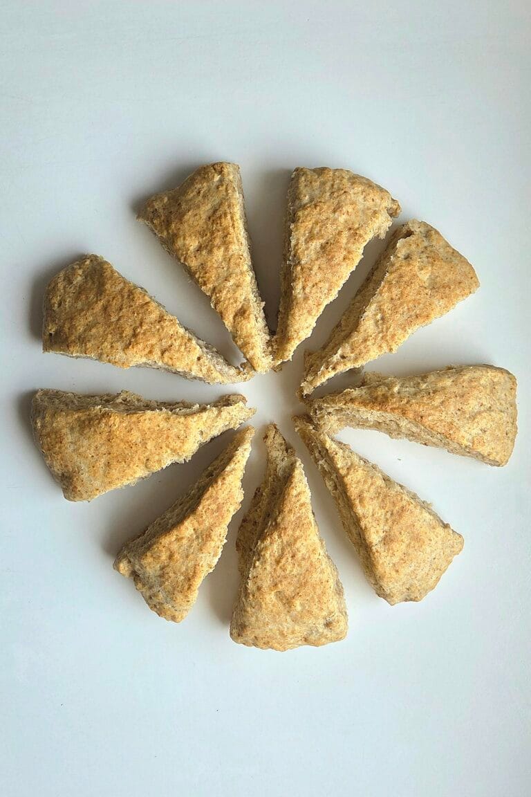 Whole wheat sourdough scones arranged in a circle on a white surface