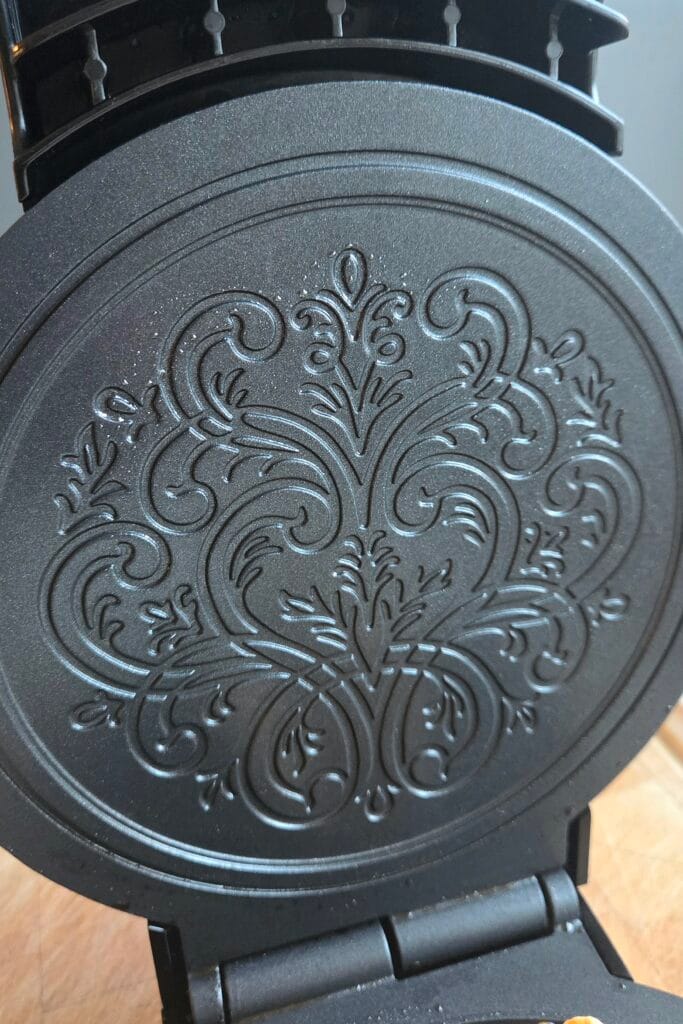 Krumkake iron with rosemaling pattern engraved into the plates