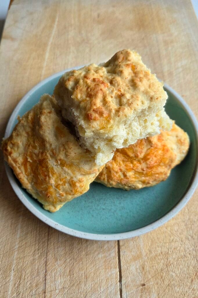 Three Jarlsberg cheese scones on a green plate