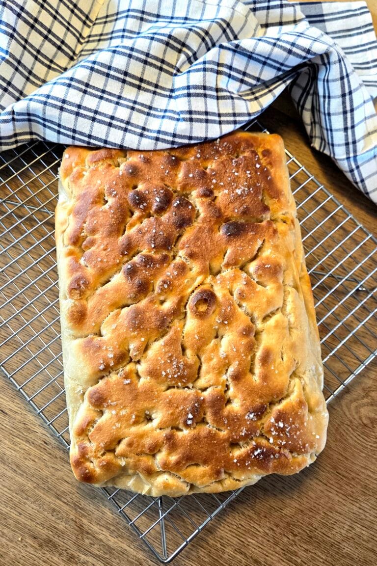 Sourdough focaccia with a golden, dimpled top, olive oil and flaky sea salt