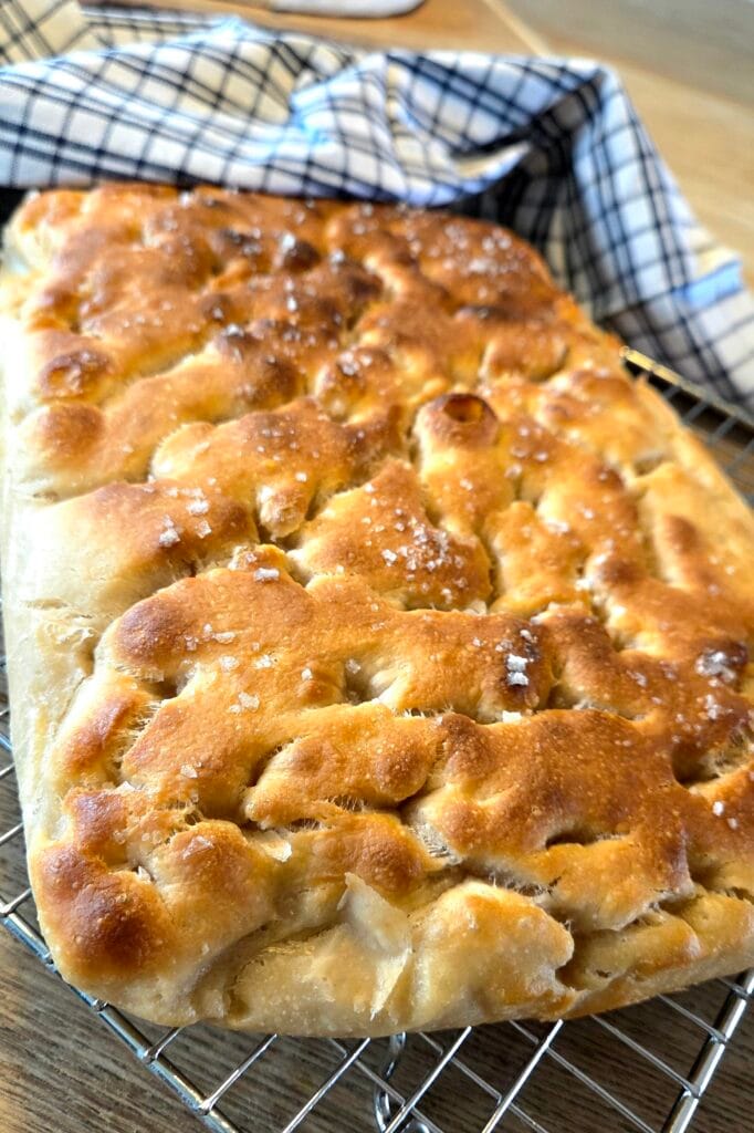 Close-up of golden sourdough focaccia crust with flaky sea salt