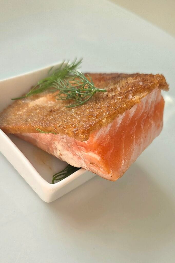 Cross-section of sourdough-crusted salmon showing the crisp bread crust fused to the fish