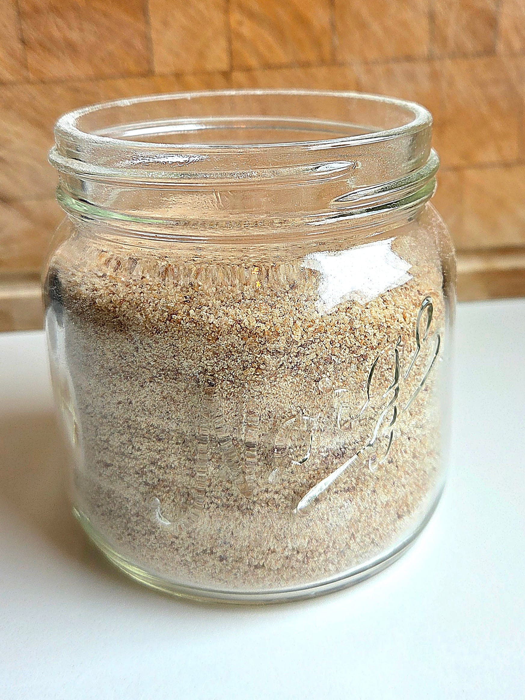 Homemade sourdough breadcrumbs in a glass jar, coarse and golden from whole grain bread