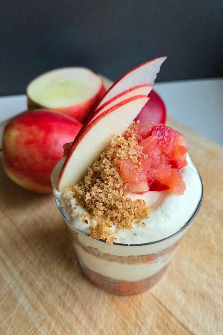 Norwegian apple trifle in a glass with layers of apple compote, buttered breadcrumbs and whipped cream