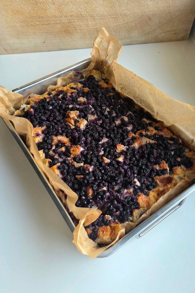 Sourdough bread pudding fresh from the oven, with jammy blueberries caramelized across the top