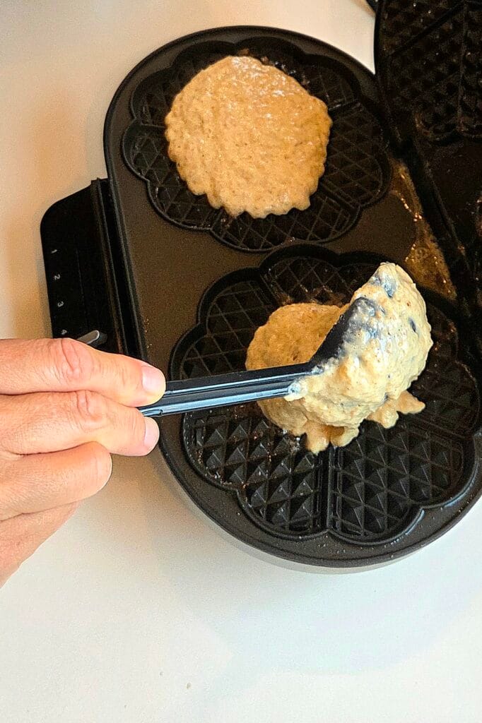 Pouring yeasted whole grain waffle batter into a heart-shaped waffle iron