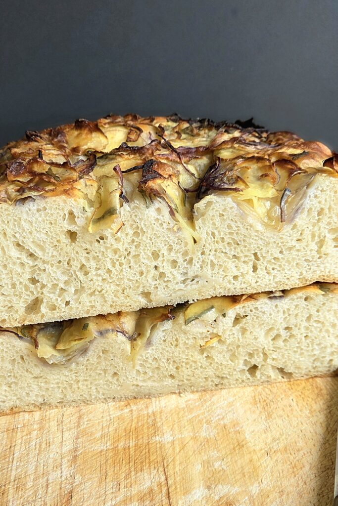 Cut potato focaccia showing the soft open crumb from mashed potato in the dough