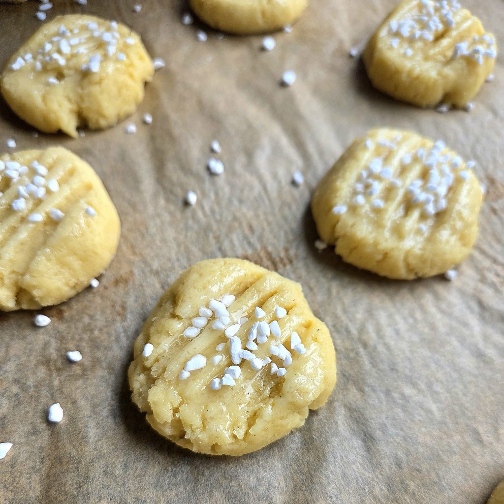 Unbaked serinakaker brushed with egg white and topped with pearl sugar