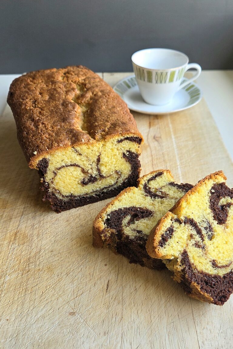 Norwegian marble cake (marmorkake) sliced on a board, showing the dark cocoa swirl through the vanilla crumb