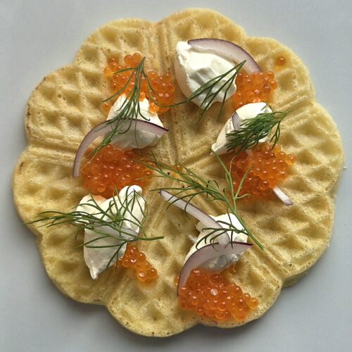 Waffles with sour cream and salmon roe: one crisp heart waffle topped with red onion and dill