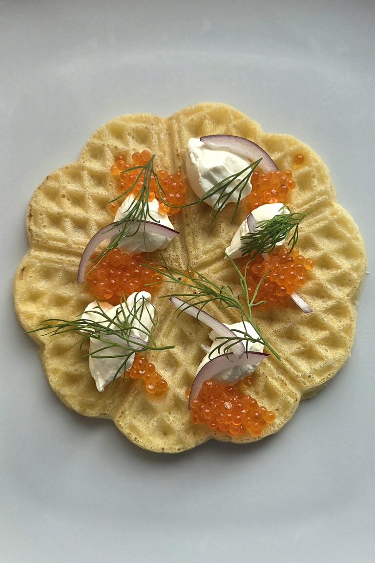 Waffles with sour cream and salmon roe: one crisp heart waffle topped with red onion and dill
