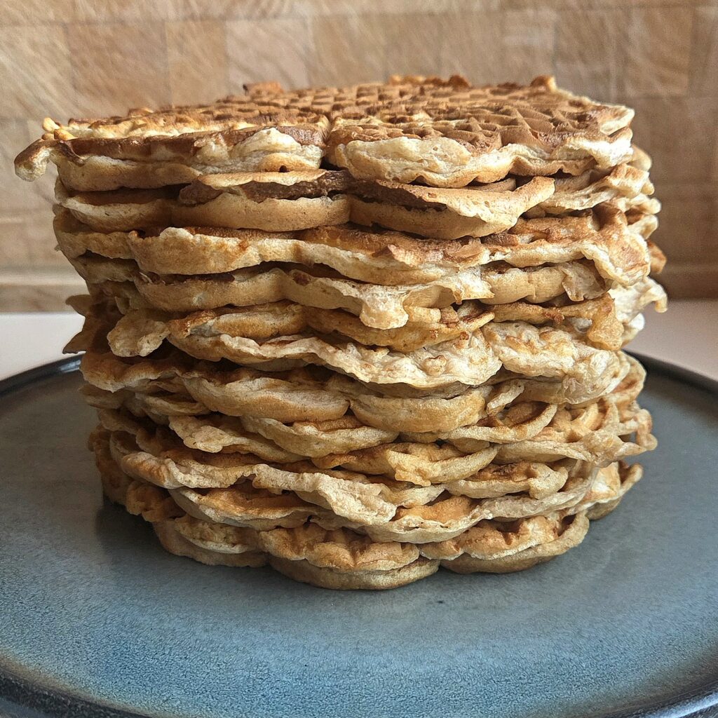 Side view of a tall stack of thin whole wheat waffles with soft, wavy edges